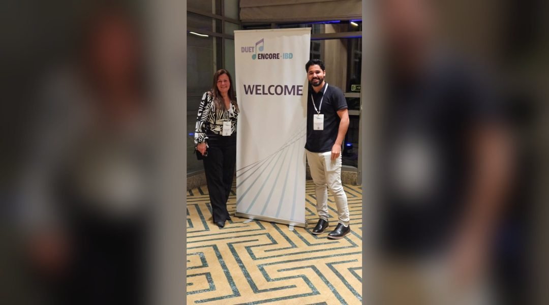 Equipe da Pesquisare ao lado do banner de boas-vindas do estudo DUET ENCORE, no Grand Hyatt São Paulo